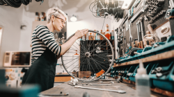 自行车店的女店主在店里摆弄轮子